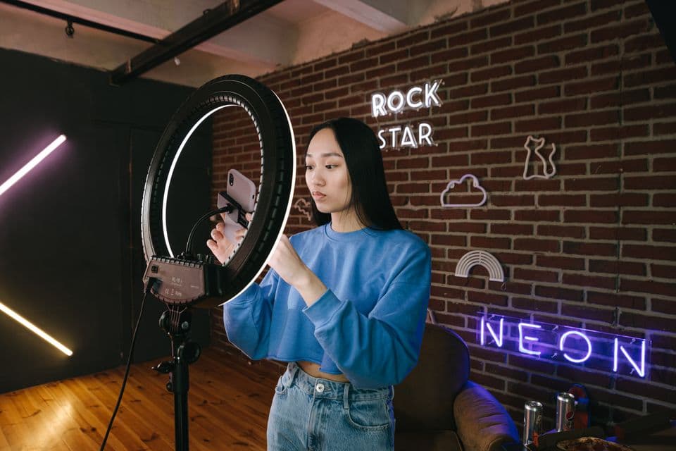 A creator setting up a phone on a ring light